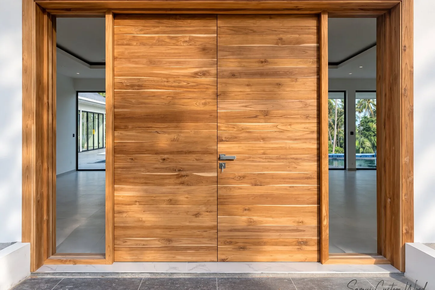 Solid teak sliding double doors filling a full-width opening